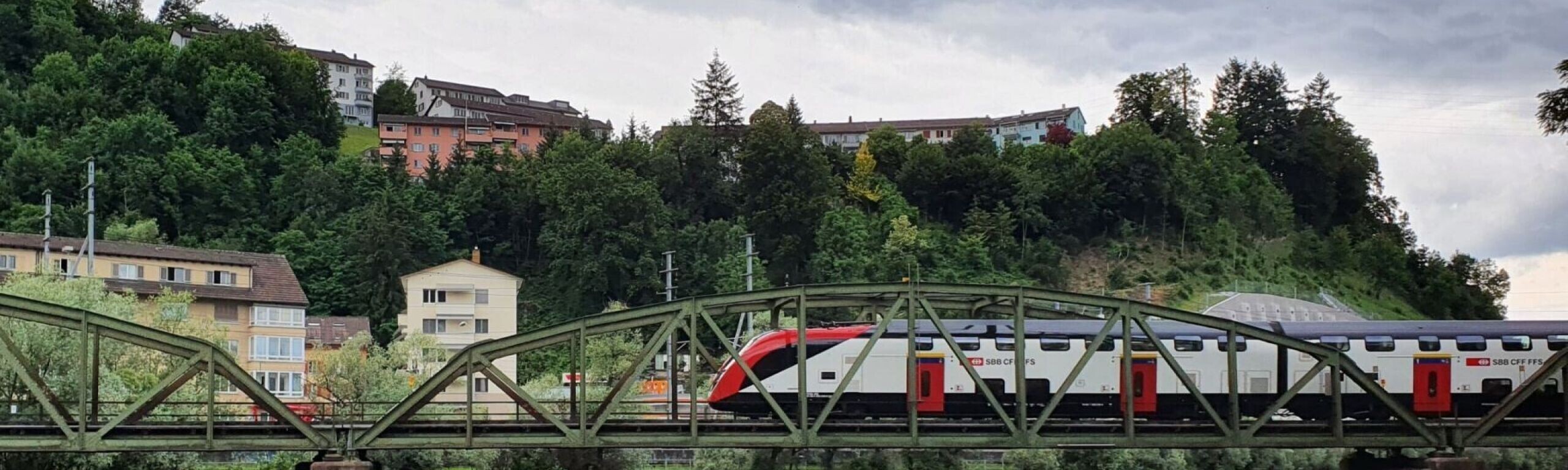 Reussbrücke Fluhmühle in Luzern. Über die denkmalgeschützte Fachwerkbrücke aus Stahl fährt ein moderner Interregio-Zug der SBB.