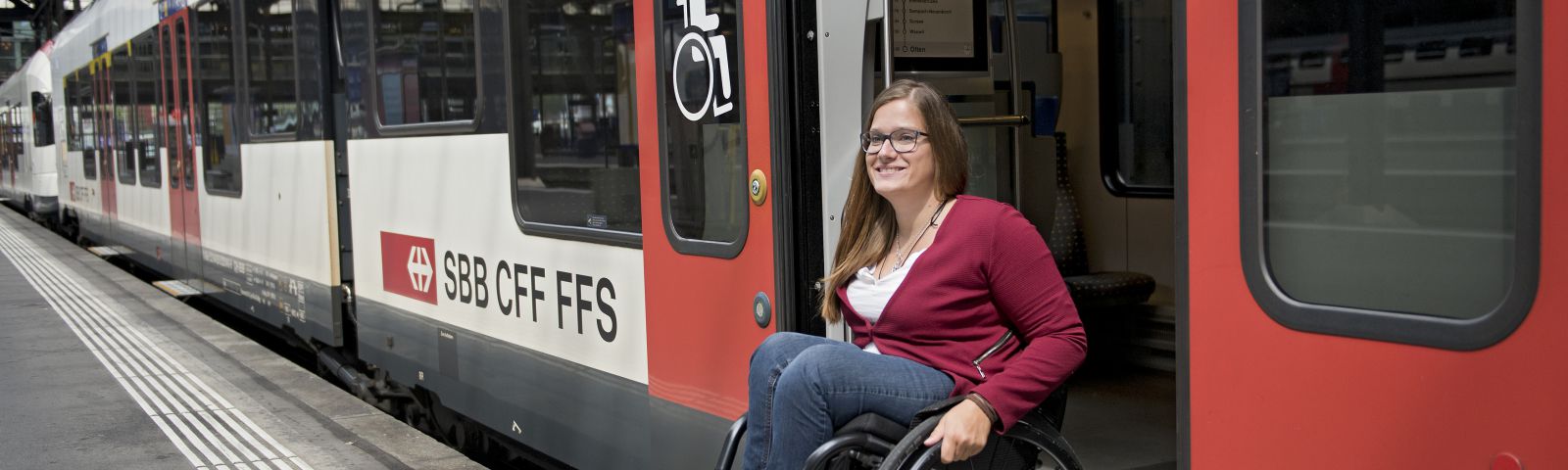 Eine Reisende im Rollstuhl verlässt den Zug.