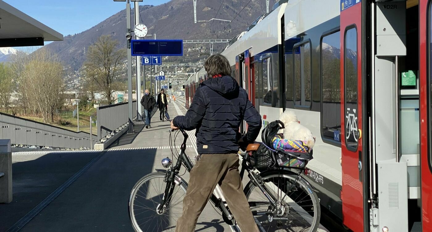 Un uomo scende dal treno con la bici