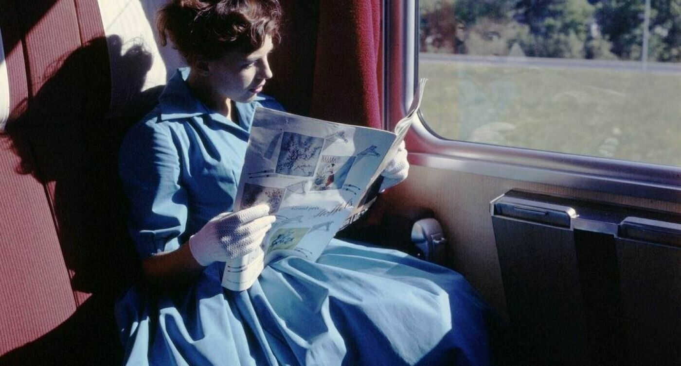 Una donna legge il giornale sul treno