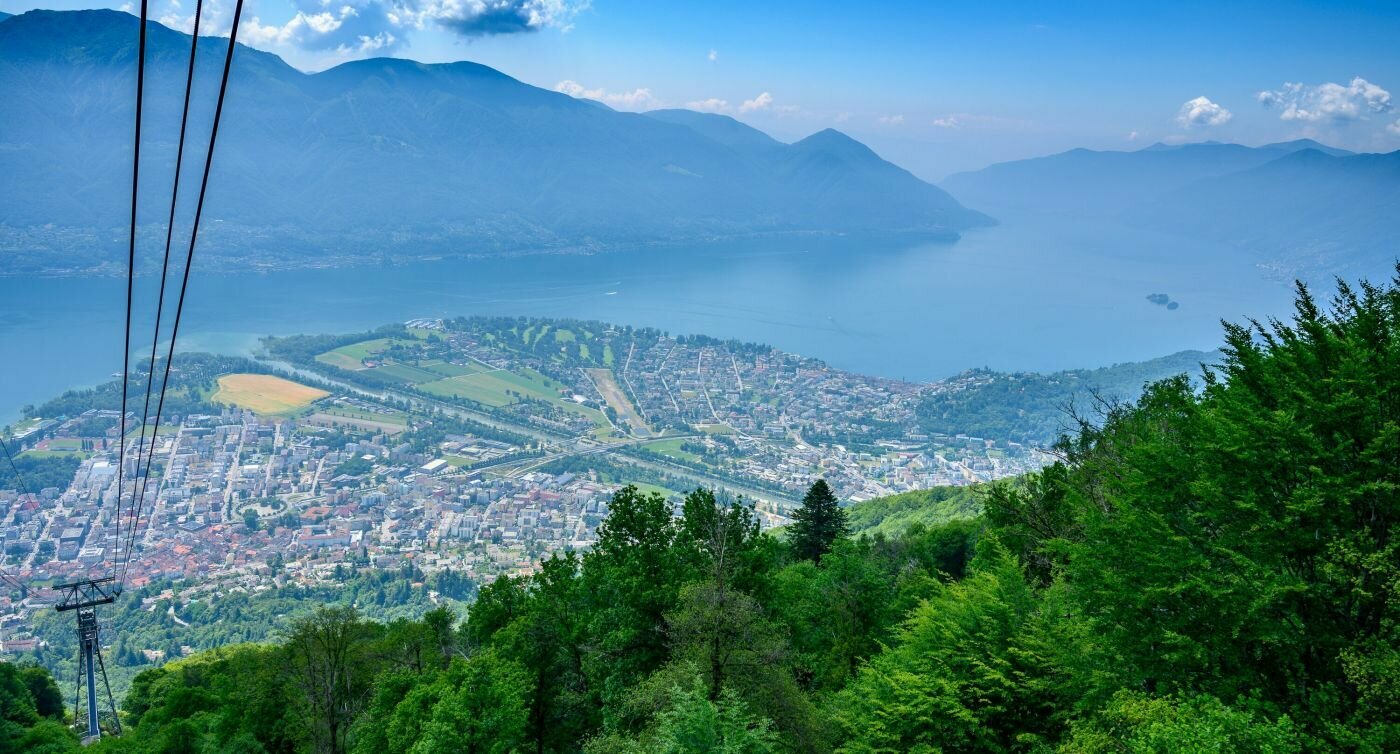 Blick aus der Gondelbahn hinunter nach Locarno und auf den Lago Maggiore.