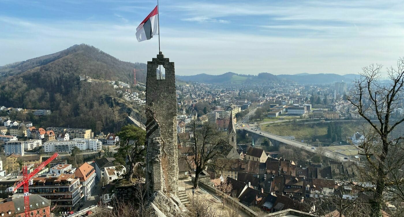 Turmruine mit Fahne, Stadt im Hintergrund