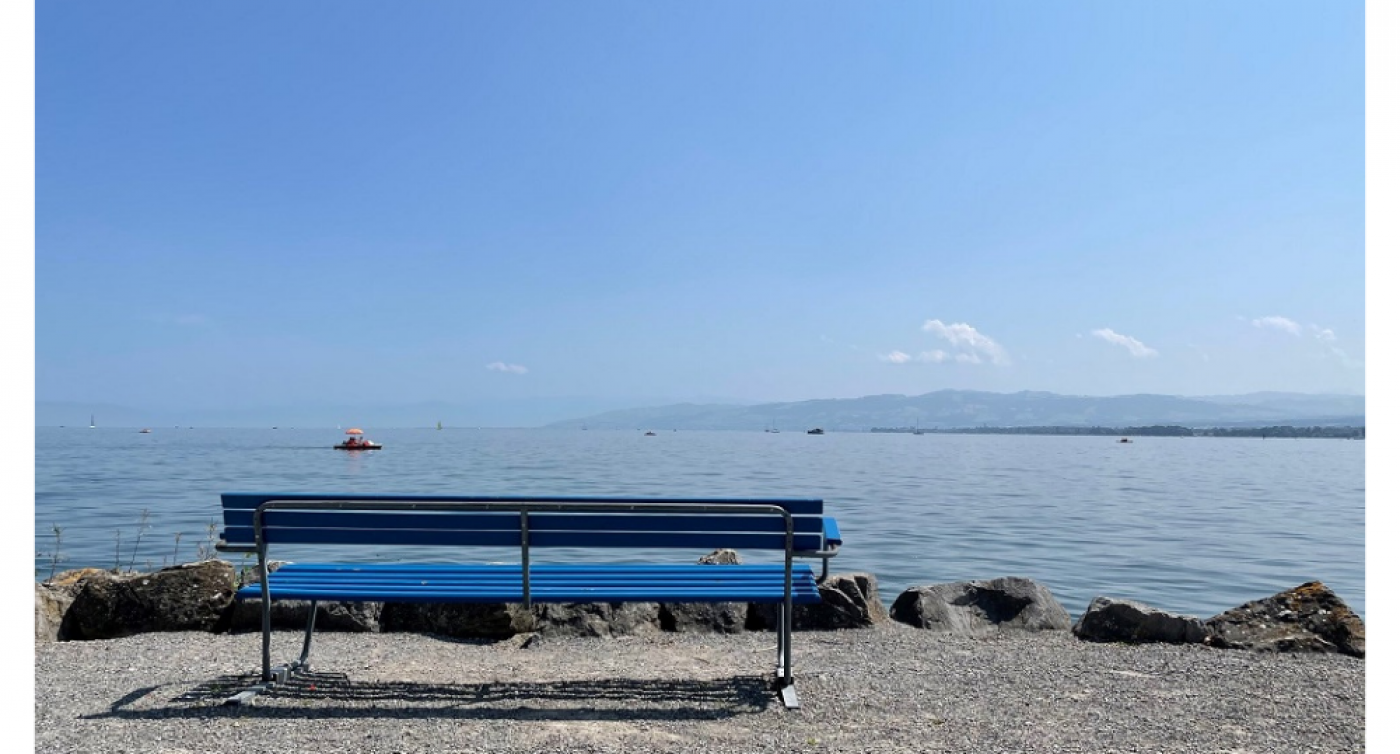 Blaue Sitzbank mit Aussicht auf See