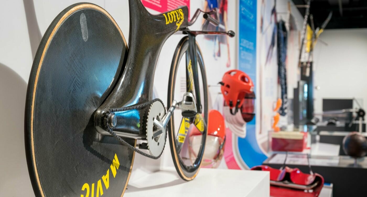 Rennrad der Marke Lotus, Helme, Ball und andere Ausstellungsobjekte aus der Geschichte der Olympischen Spiele.