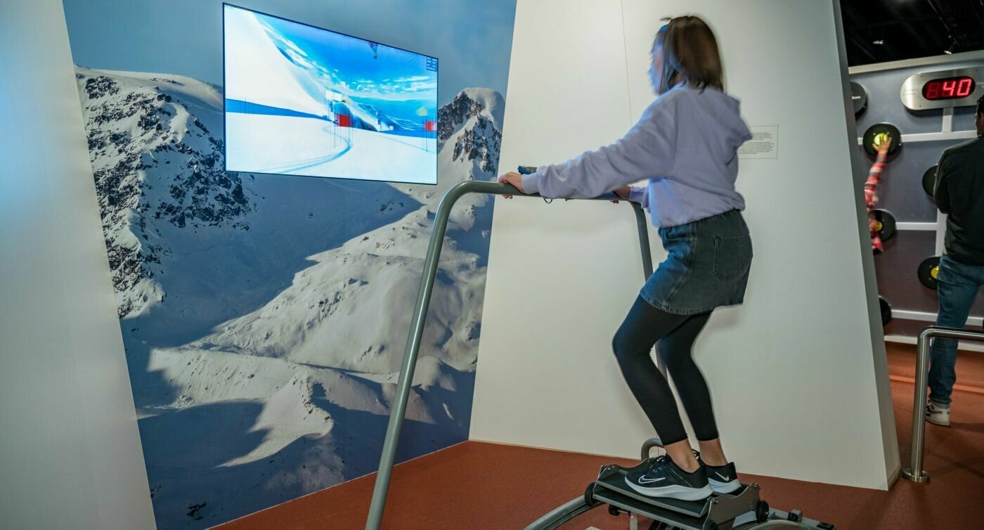 Mädchen steht auf Ski-Simulator im Olympischen Museum.