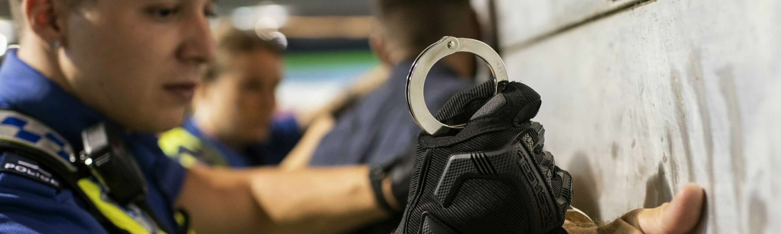 Ein Polizist legt jemandem Handschellen an