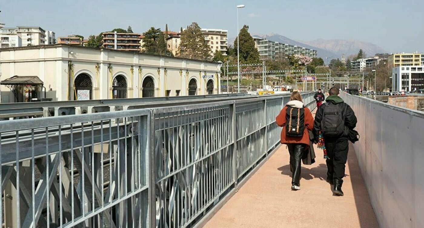 Due persone che camminano mano nella mano sul ponte