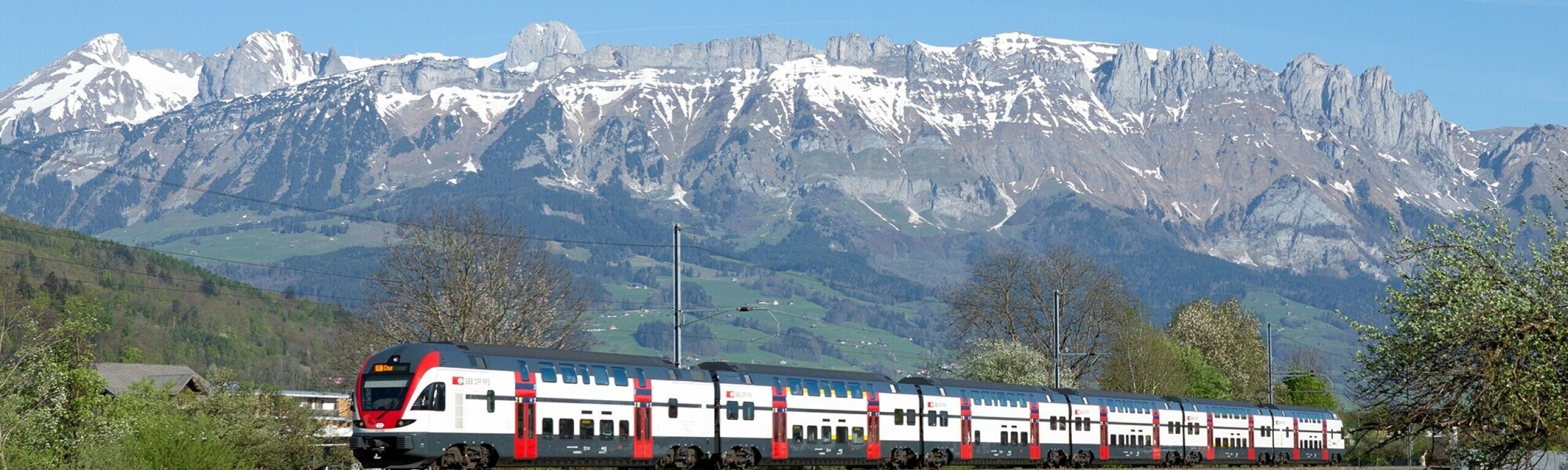 Ein Zug fährt durch die Landschaft des St. Galler Rheintals.