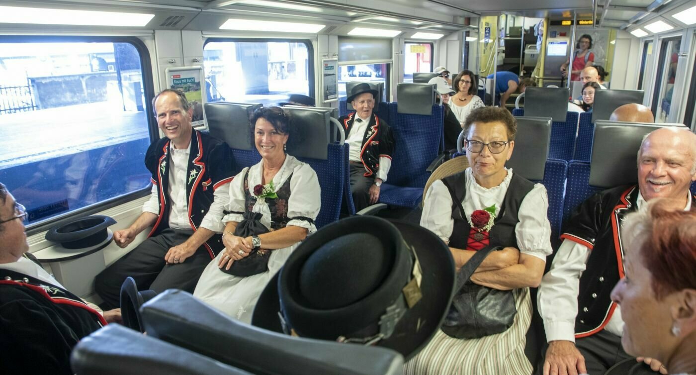 Passeggeri in costume tradizionale si accovacciano sul treno