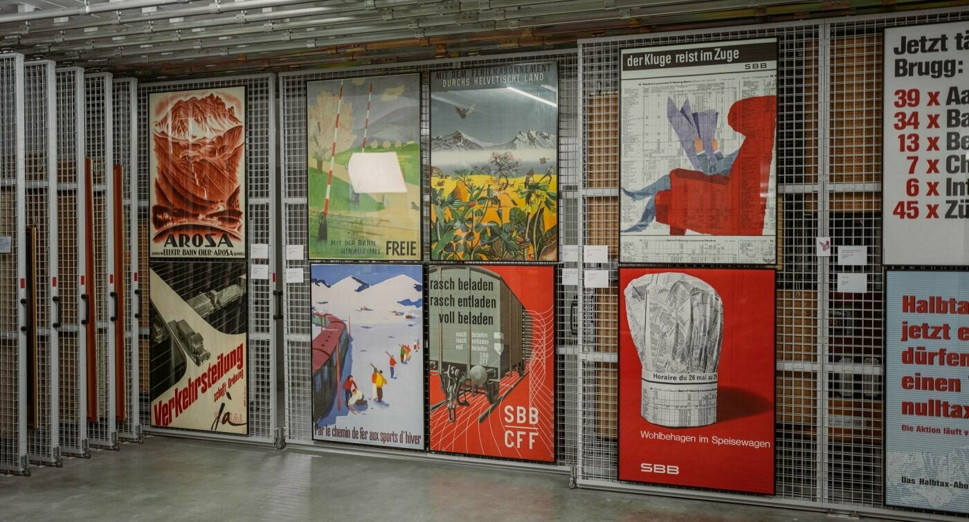 Affiches illustrées suspendues sur un mur grillagé
