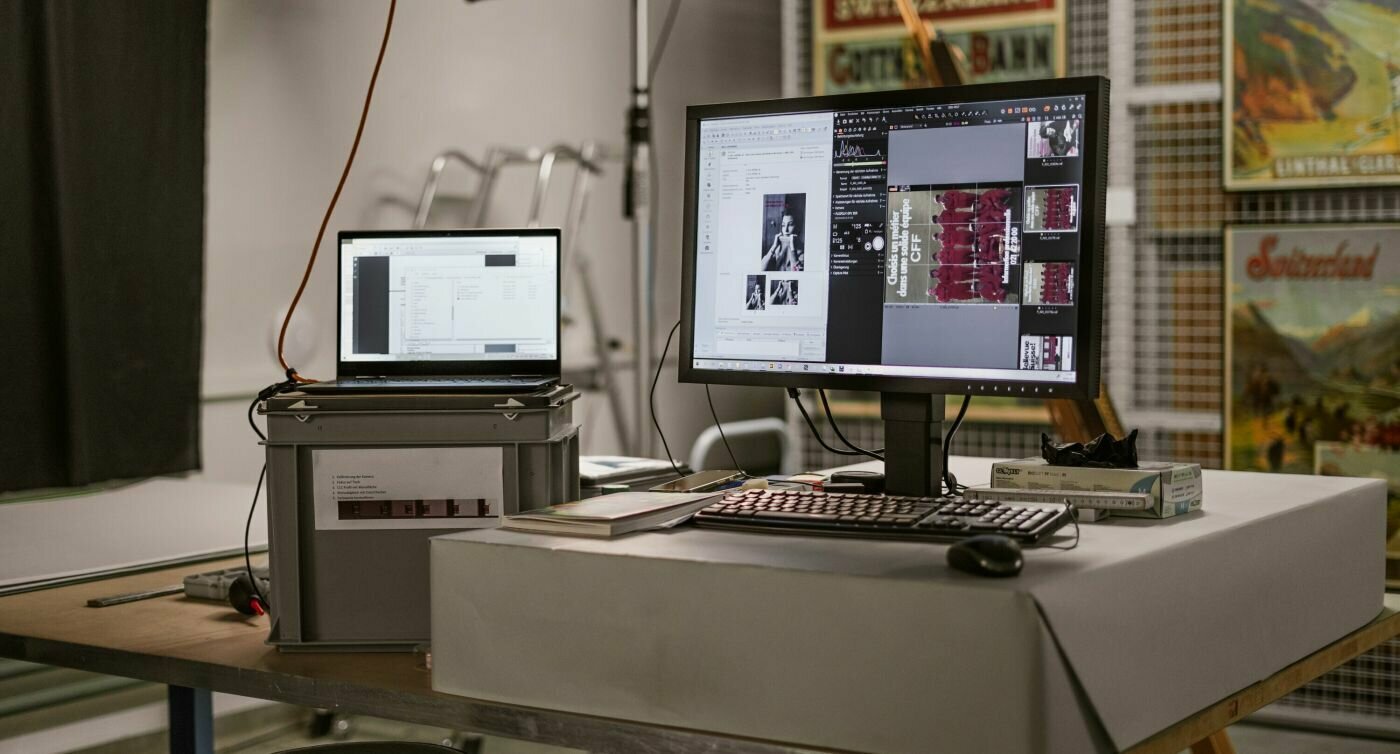 Un computer portatile e uno schermo su cui vengono digitalizzati i poster