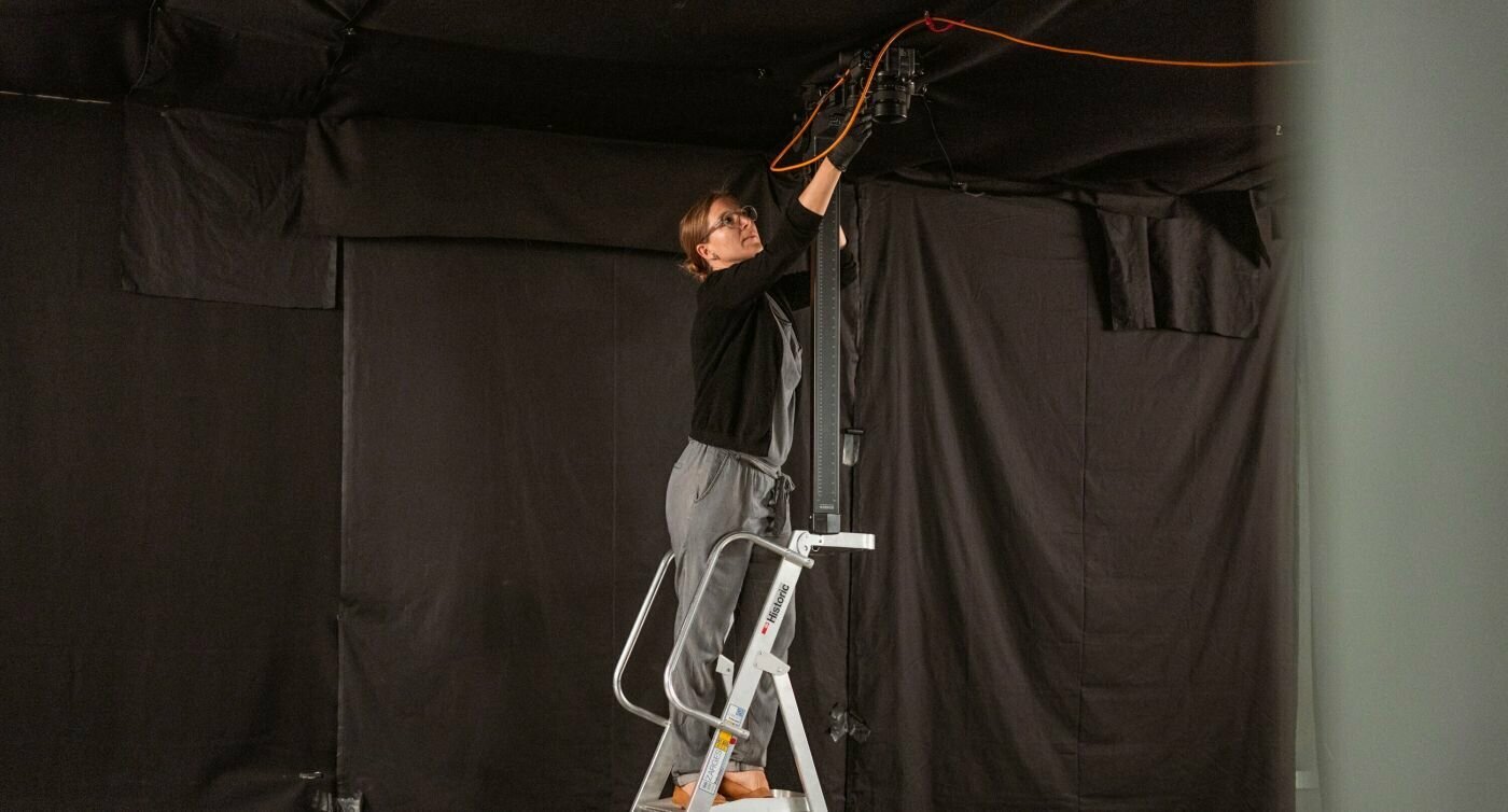 Andrea Kuratli è in piedi su una scala e posiziona la fotocamera