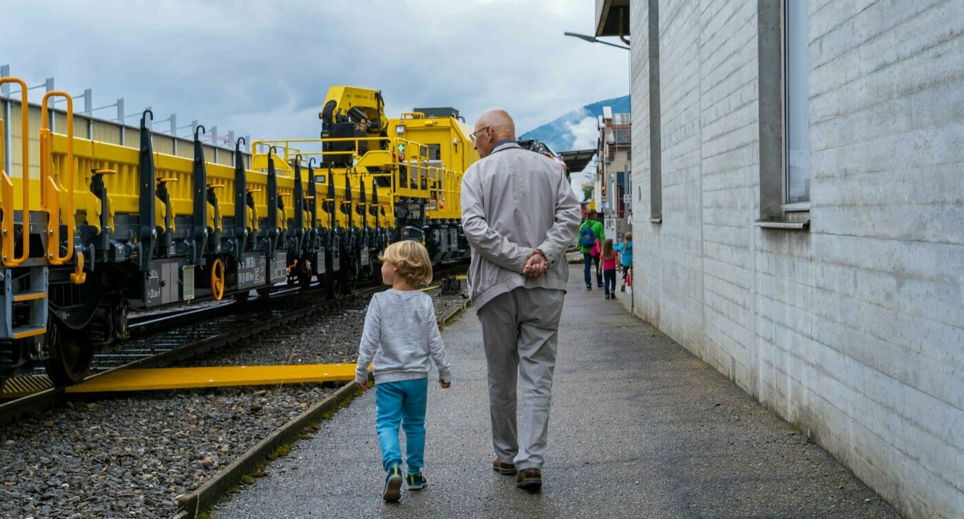 Un enfant et un vieil homme regardent un train.