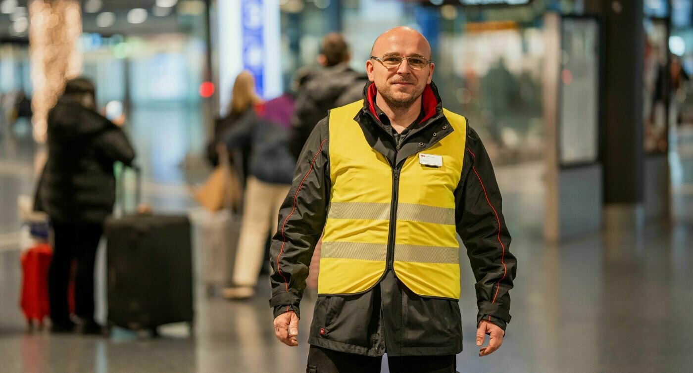 Dusan Sarcevic se tient devant les affichages de départ des CFF à l'aéroport de Zurich.