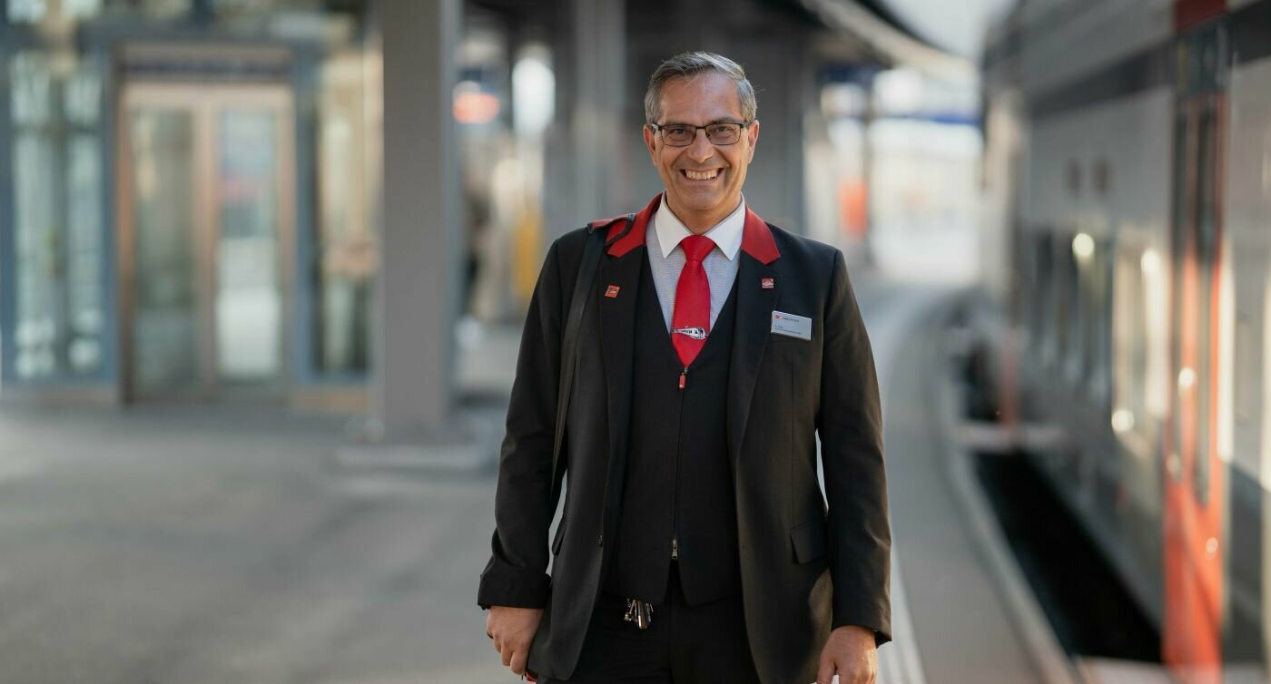 Fabio Pala souriant et posant devant l’objectif sur un quai près d’un train.