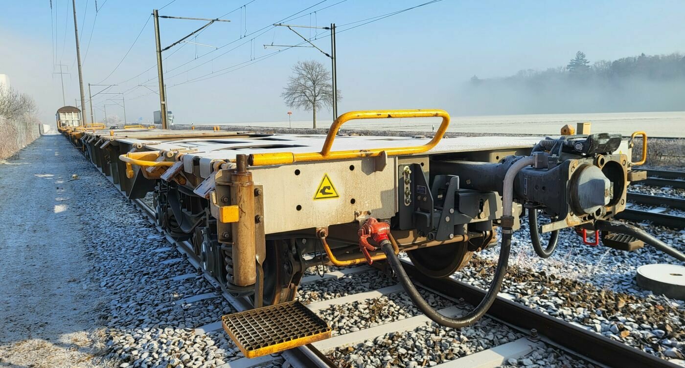 Le train d’essai est garé sur une voie ferrée en zone rurale. En point de mire, un wagon équipé d’un embrayage automatique numérique.