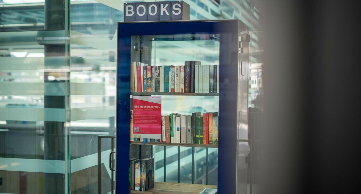 Una libreria con un'anta di vetro contenente libri