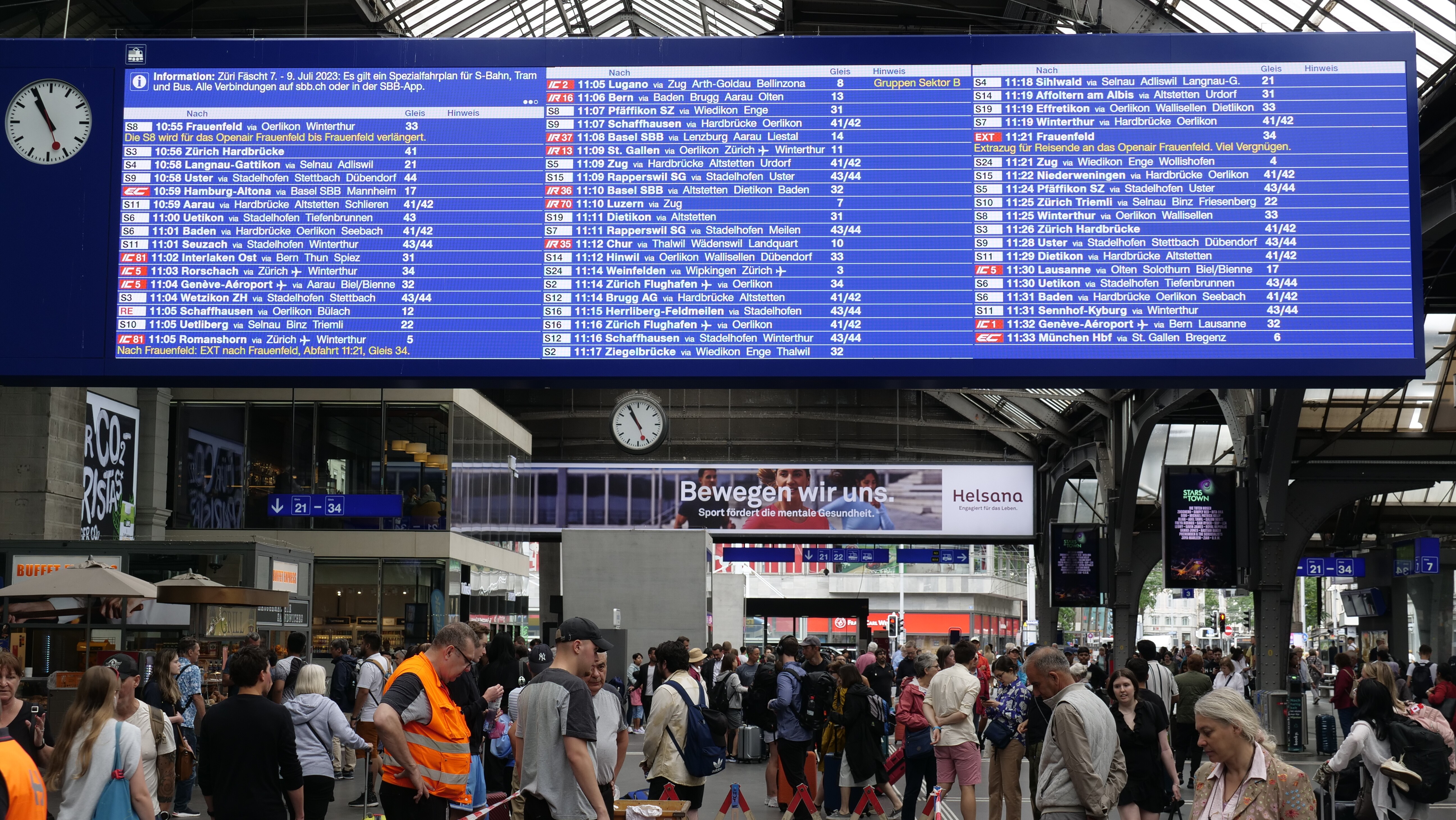 Il tabellone degli orari della stazione di Zurigo con una barra grigia sopra la tabella delle partenze e i collegamenti successivi ordinati per orario di partenza, con la stazione terminale visualizzata per prima, seguita dalle fermate intermedie. Le informazioni su un evento attuale appaiono in alto a sinistra.