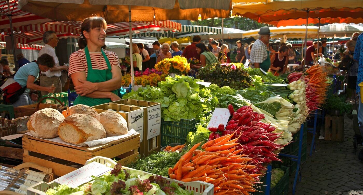 Marktstände mit Gemüse und Früchten.