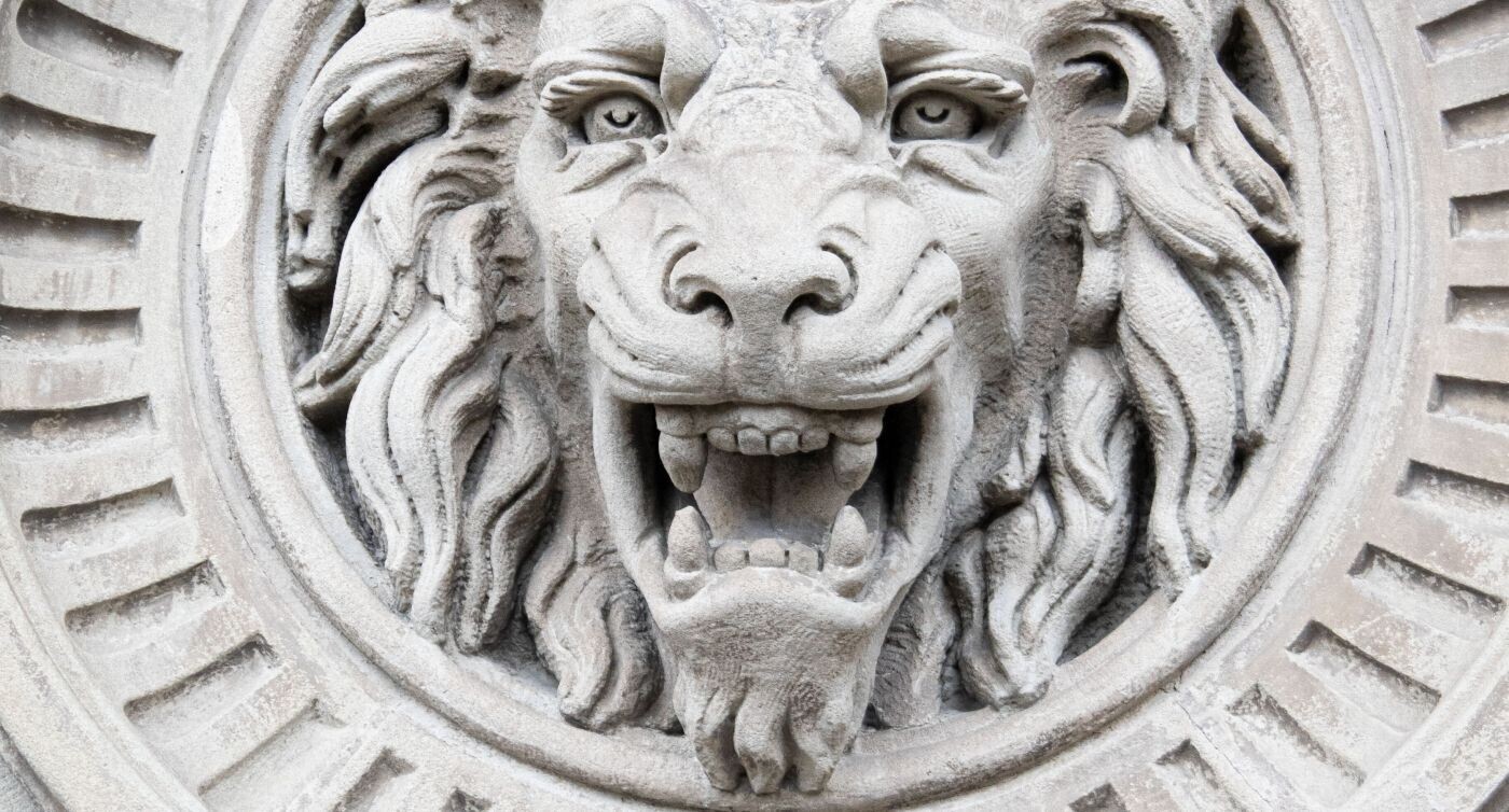 Der Kopf eines brüllenden Löwen aus Sandstein ziert die Fassade.  