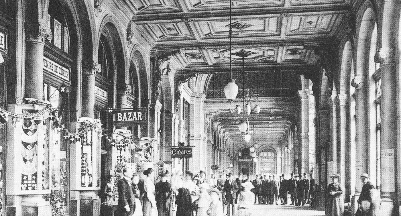 Geschäfte und Passanten in der Bahnhofspassage des Zürcher Hauptbahnhofs. Bild von circa 1900.