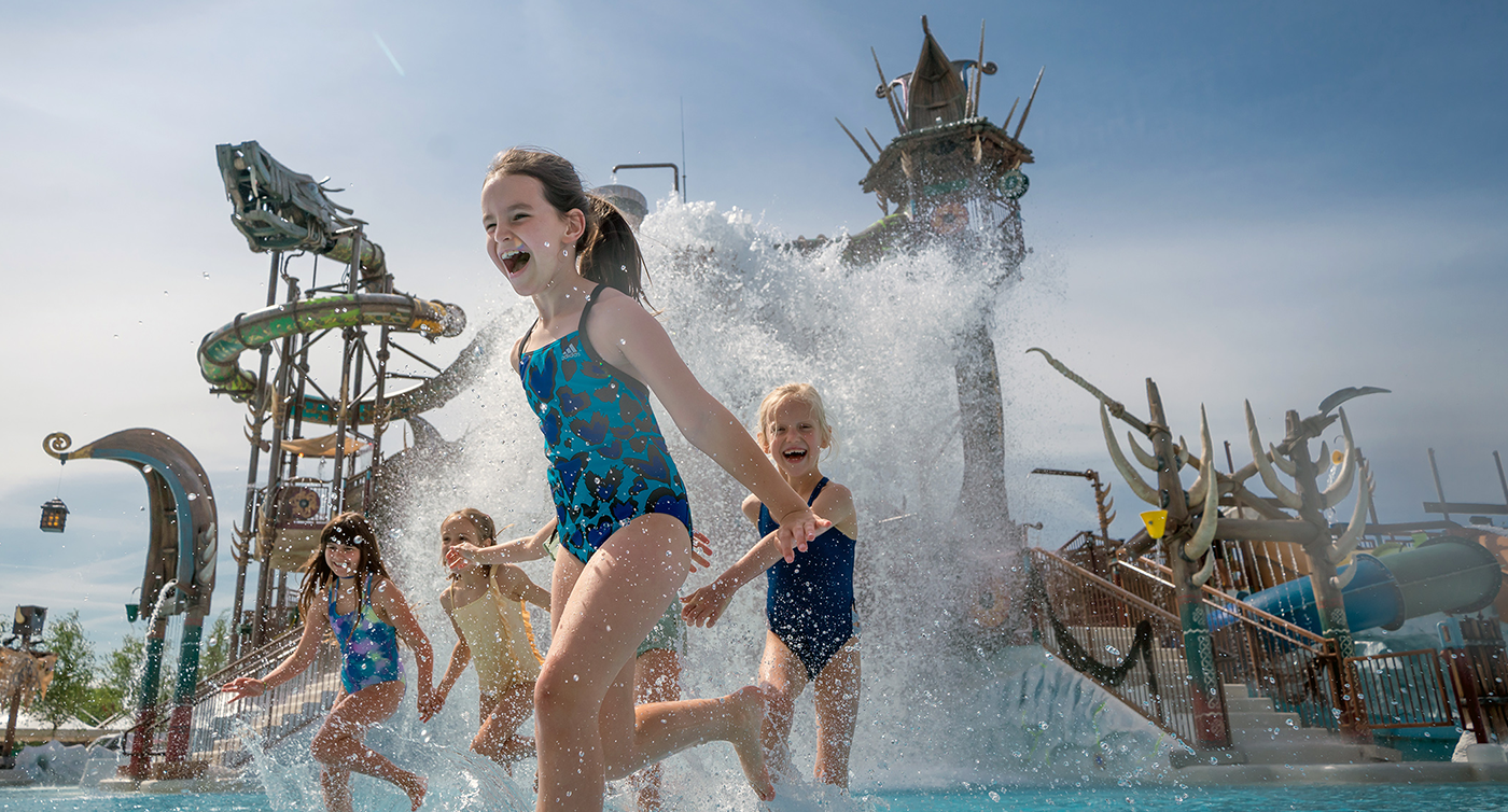 Alcuni bambini saltellano felici in una delle piscine del parco.