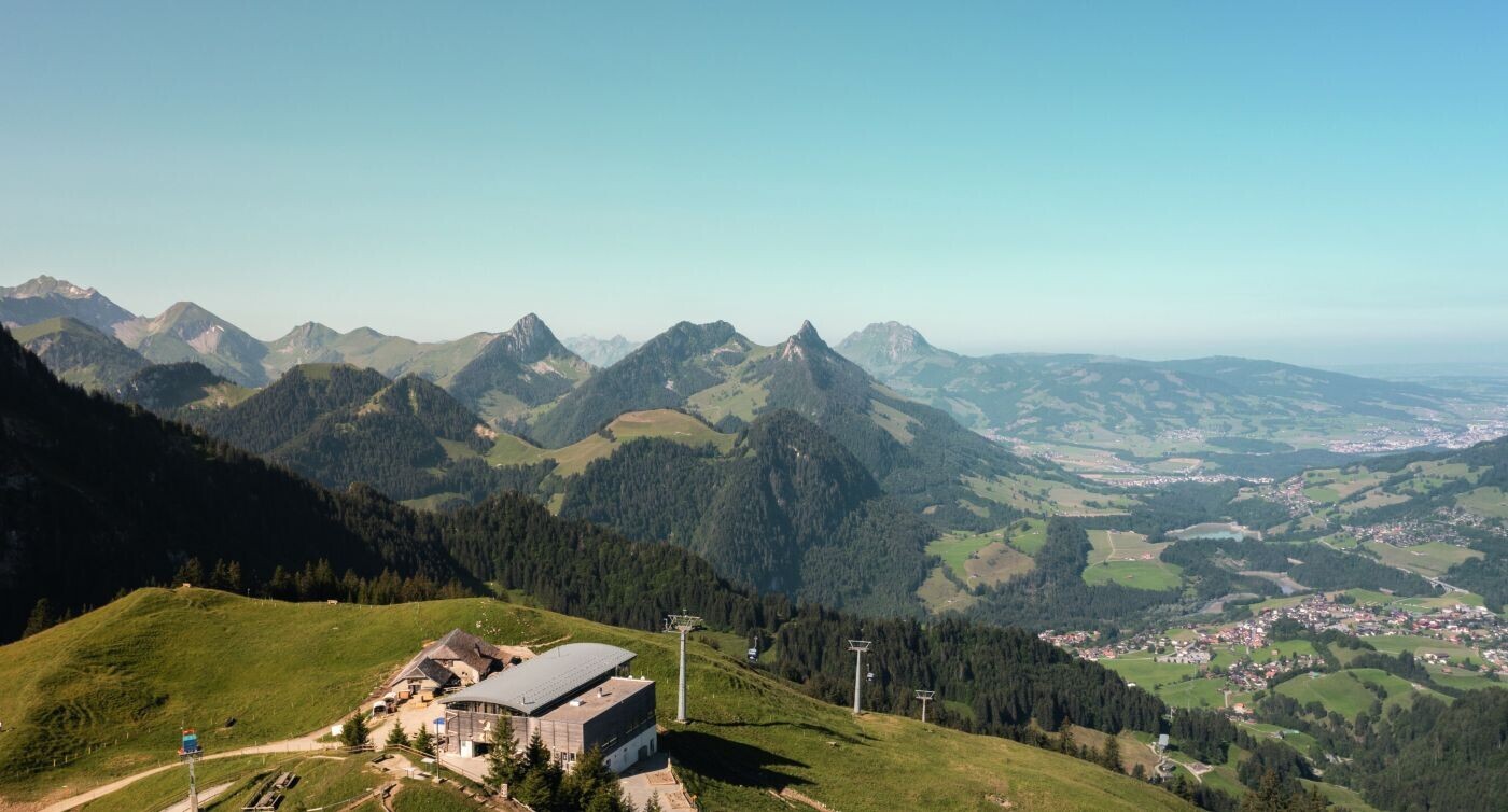 Blick auf die Bergstation der Gondelbahn in Vounetz. Im Hintergrund sind die Freiburger Voralpen und das Greyerzerland zu sehen.