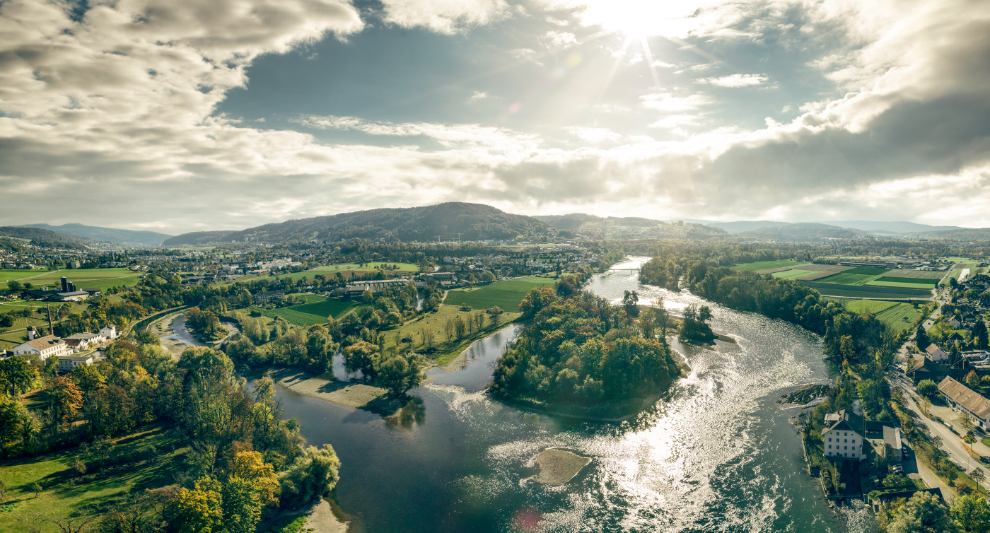 Vue aérienne sur le Seetal: on aperçoit des bras de rivières, un château et des montagnes au loin.