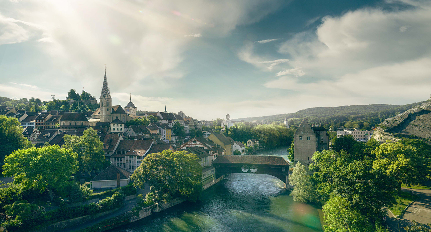Blick auf die Altstadt von Baden, die Limmat sowie die historische, gedeckte Holzbrücke.